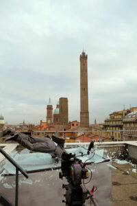 Stuntman su tetto bolognese, sfondo due torri